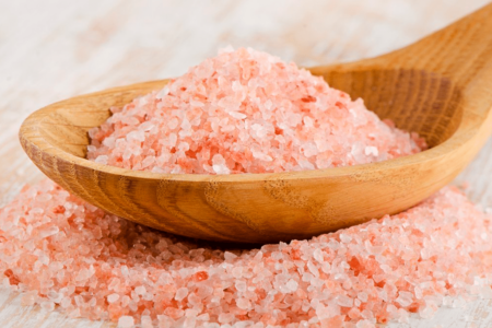 Por qué la sal rosada del Himalaya es tan popular 1 Cristales de sal rosada del Himalaya en un recipiente de cocina